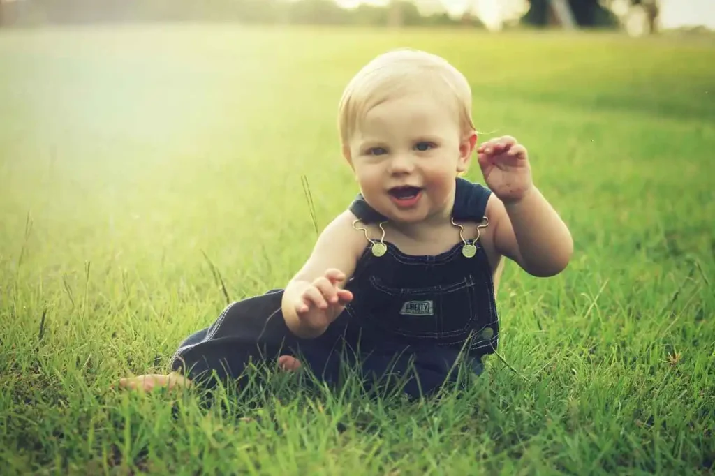 Une adorable fille en robe noire s'amuse dans un champ