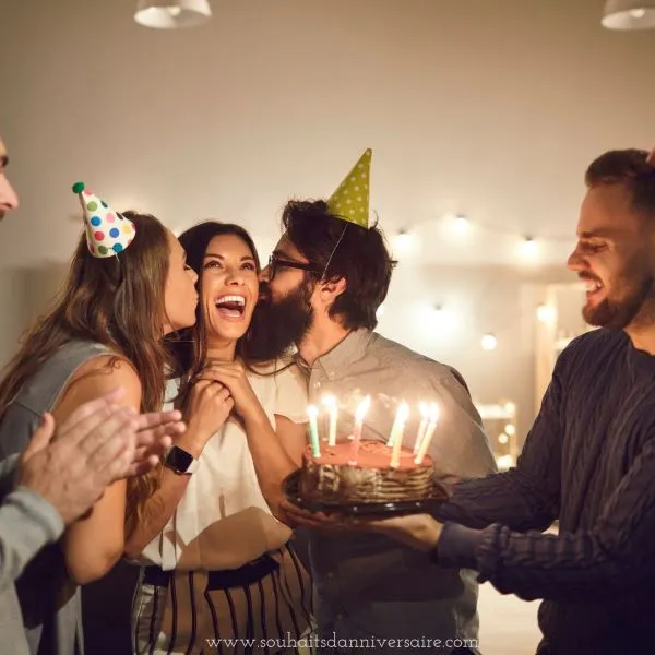 Instantané d'une fête d'anniversaire animée : les amis sont plongés dans le rire et la joie. La fêtée reçoit des baisers affectueux de la part de ses amis,