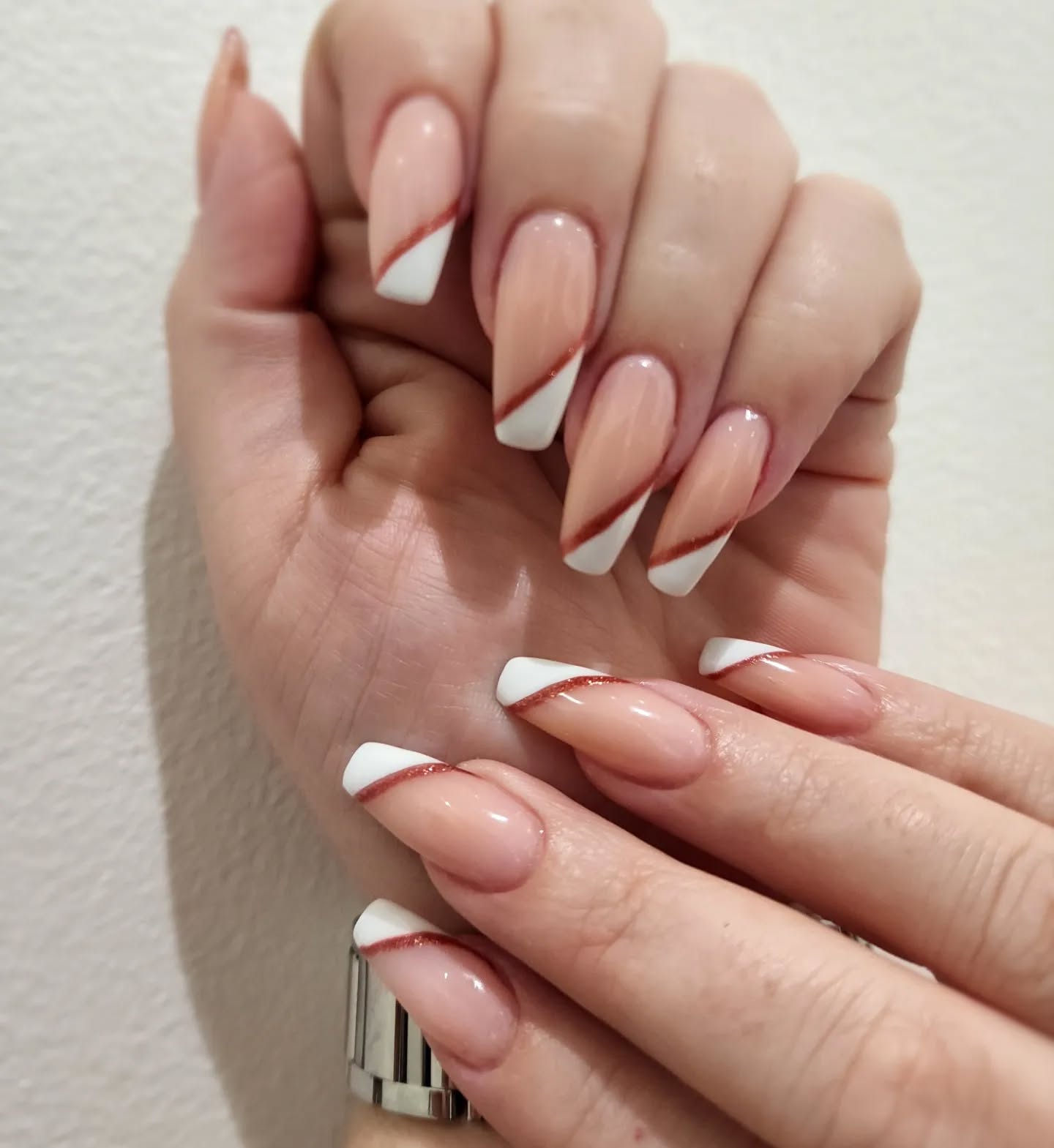 Light pink nails with a soft swirl and heart design.