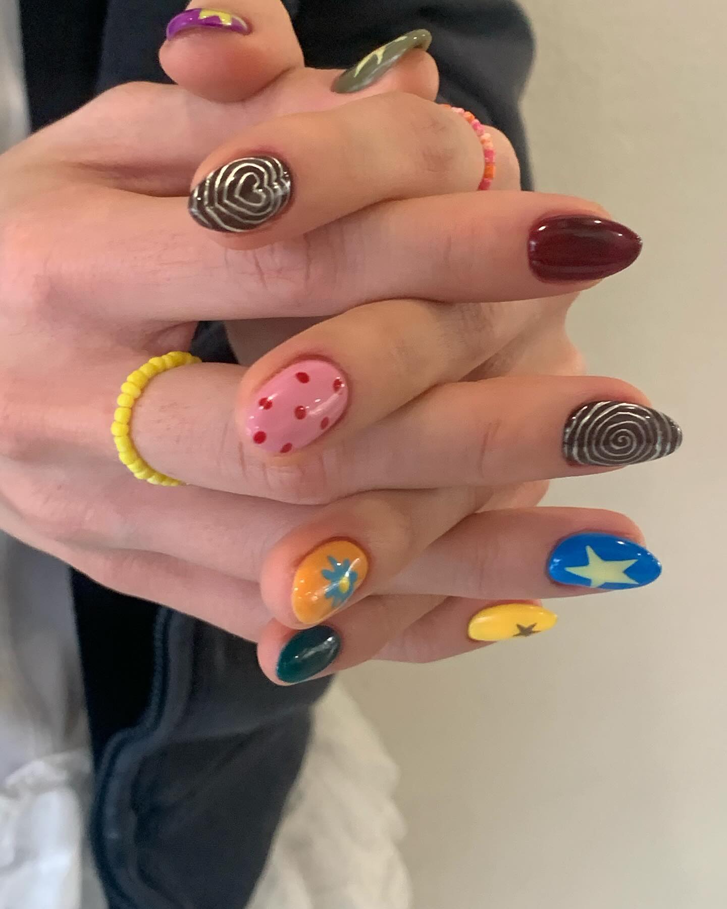 Colorful, cartoon-style mismatched nail art.