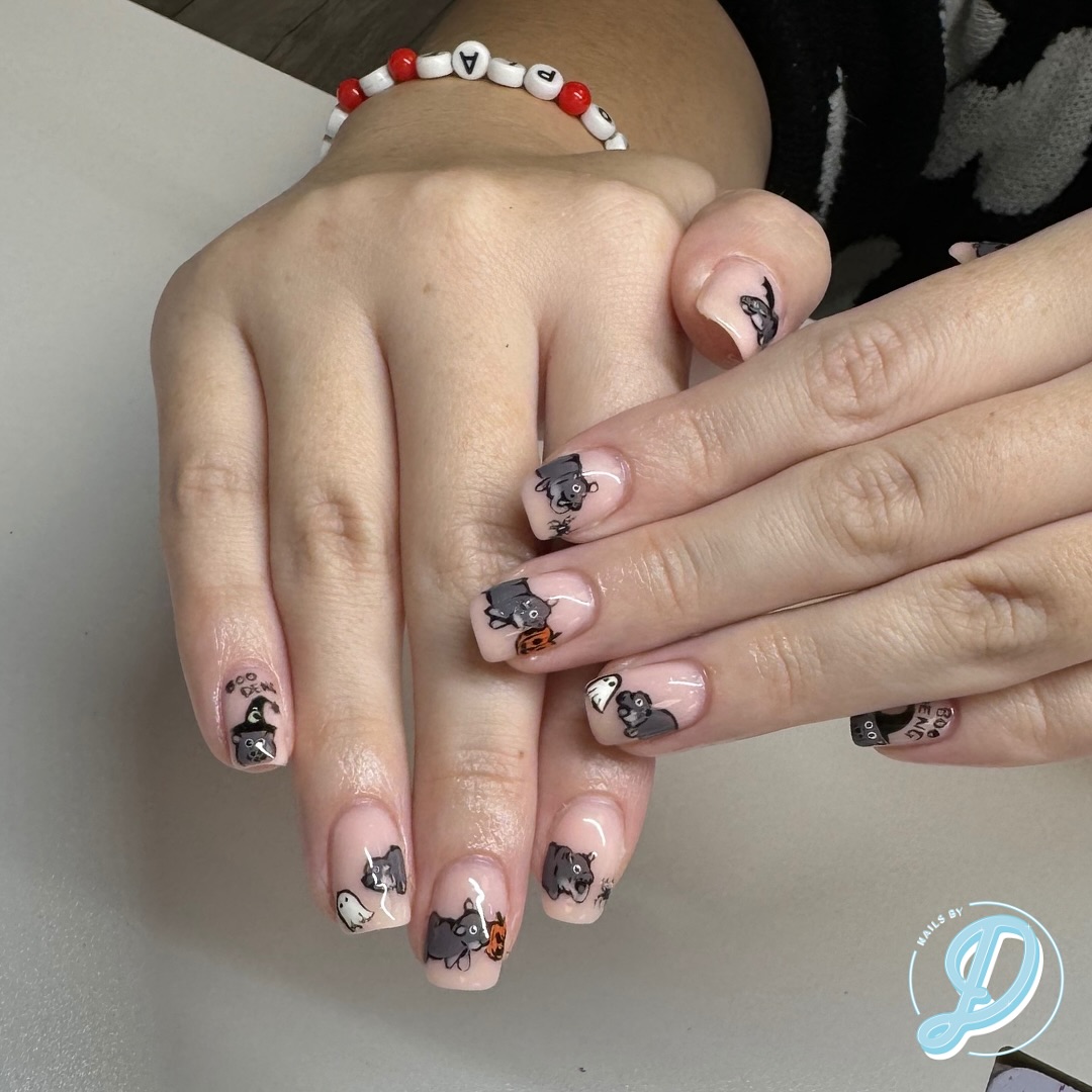 Halloween themed nails with cartoon cats and ghosts.