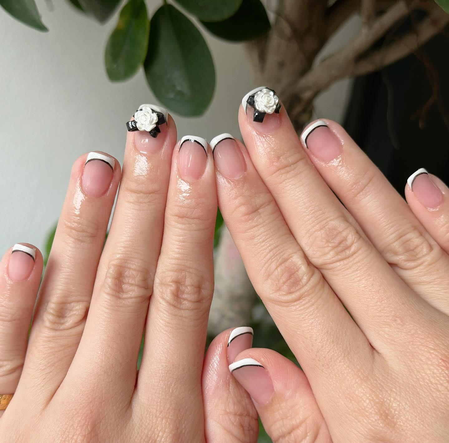 White French tip nails with black ribbon roses.